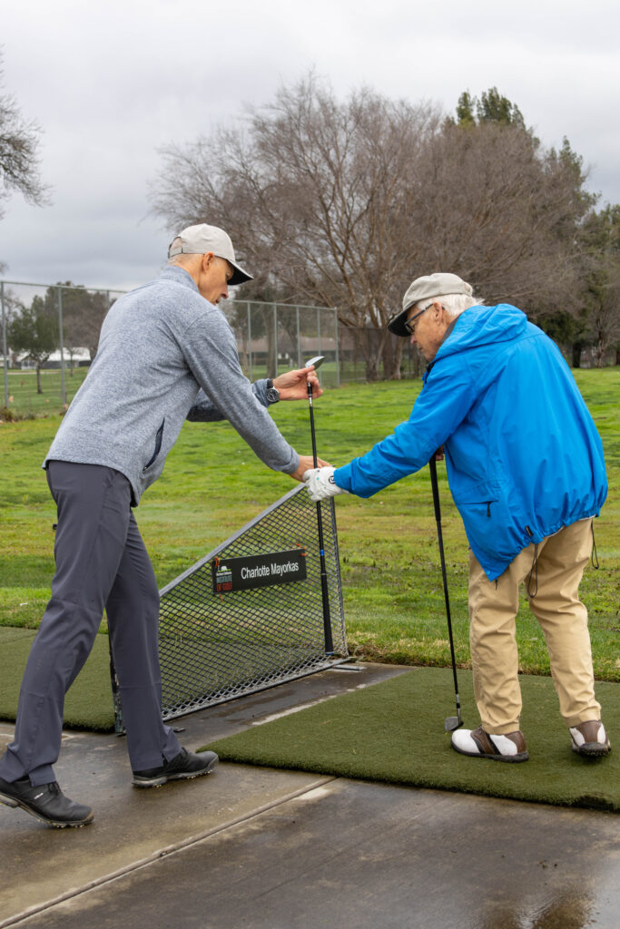 Will Karnosky instructing a veteran at the Haggin Oaks Driving Range