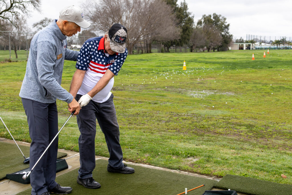 Will Karnosky instructing a veteran at the Haggin Oaks Driving Range