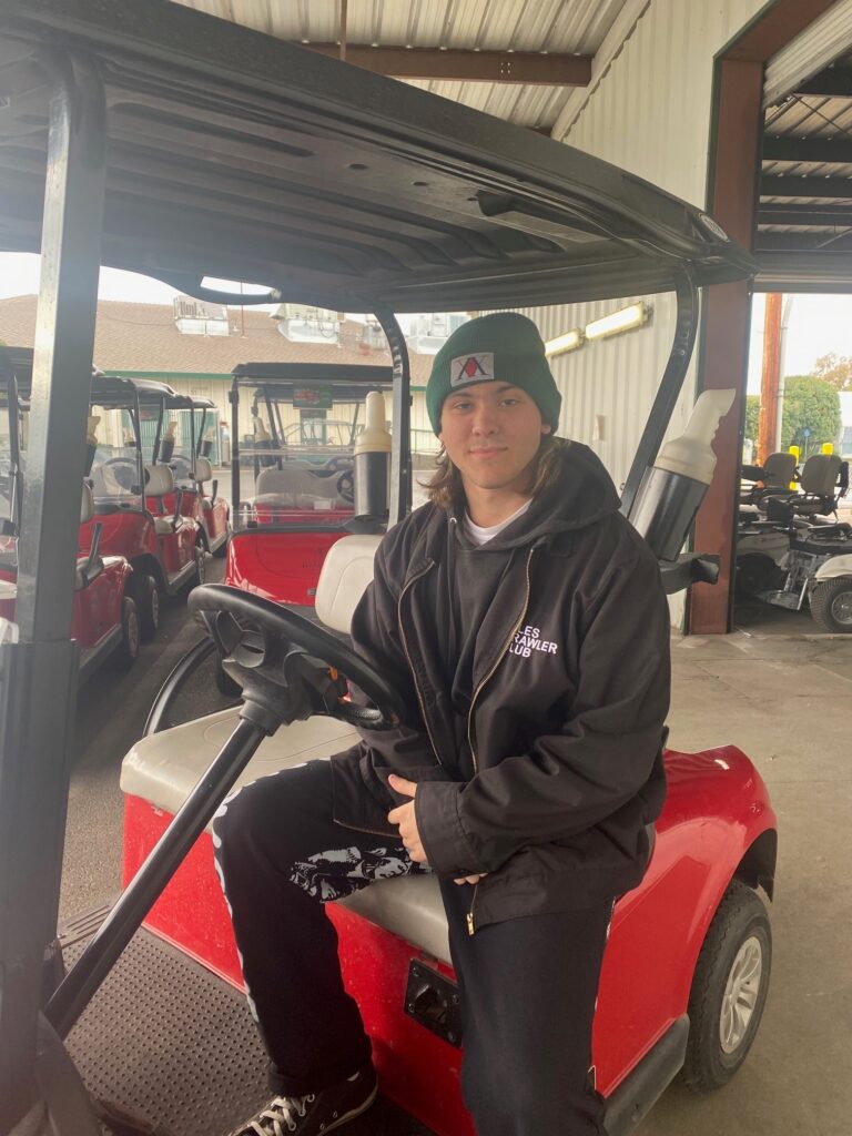 Will Curtsinger sitting in a golf cart