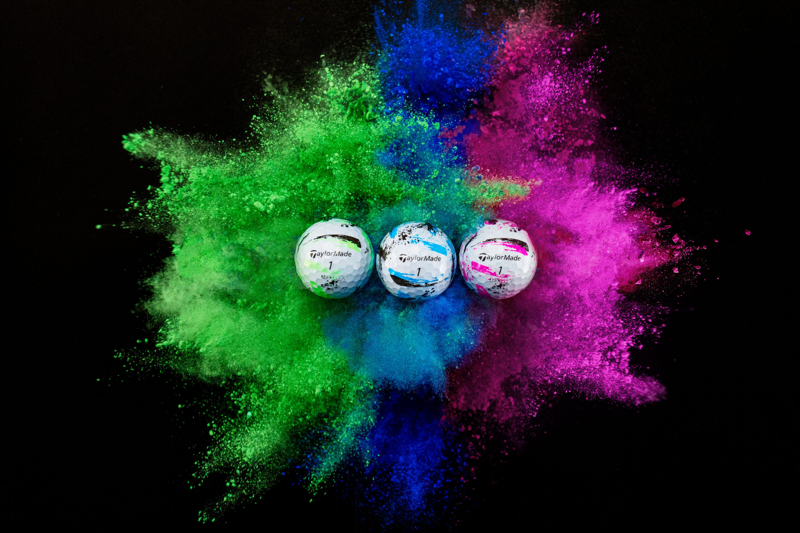 3 golf balls with green, blue and pink paint splatter background