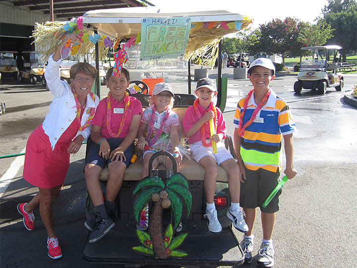 Kids dressed up in Hawaiian theme on golf cart