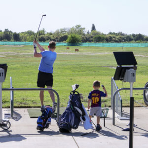 Golfer and Child at Driving Range