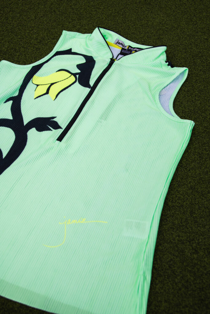 green tank top with black and yellow flower on grass background