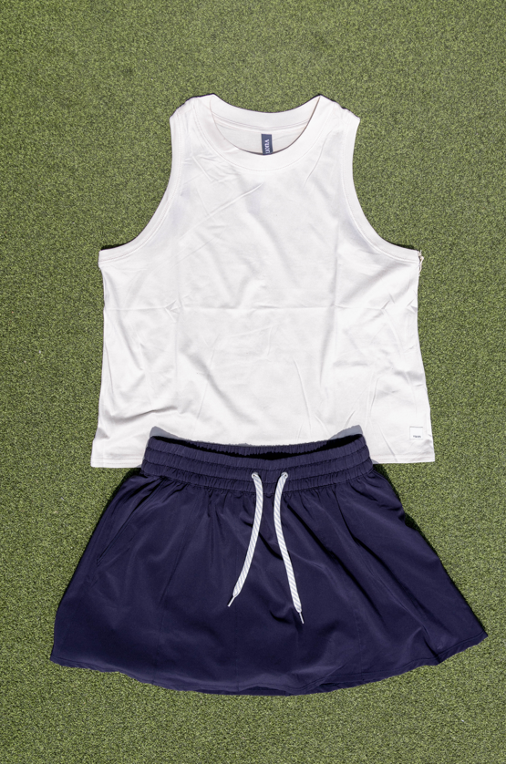 white tank top with blue shorts on grass background