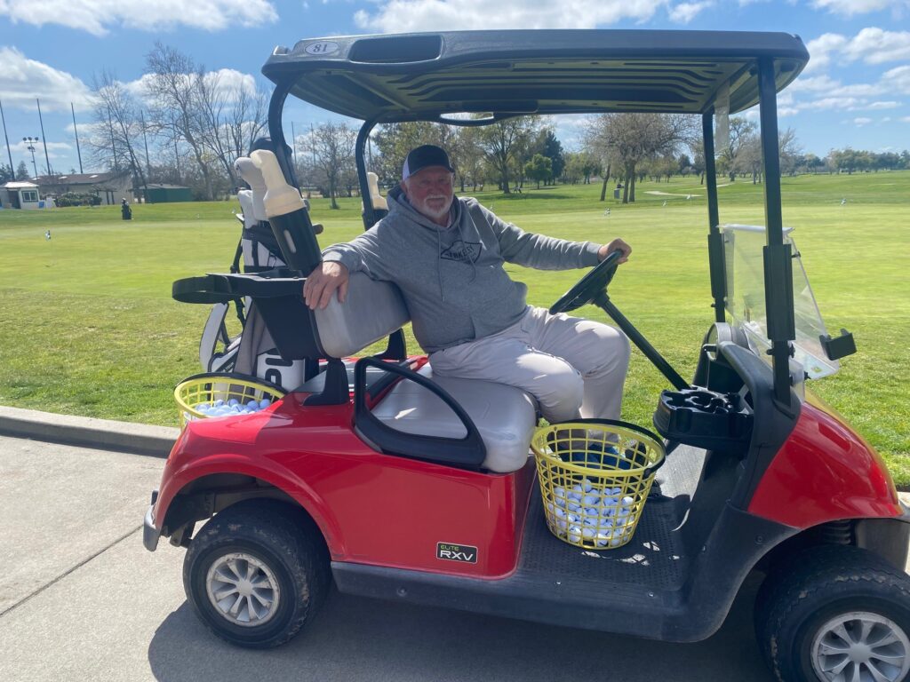 Man in red golf cart