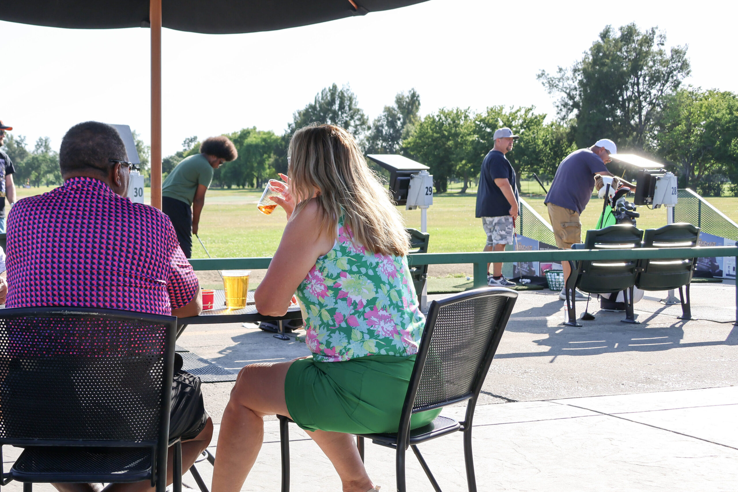 a couple in the foreground eating with golfers in the background