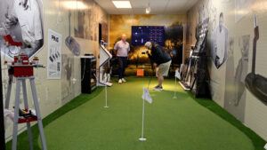 A wide shot of the Haggin Oaks Putter Fitting Studio. A golfer is getting a fitting with an employee.