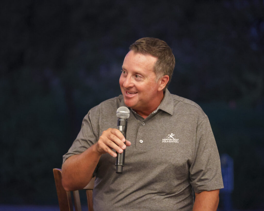 Tom Morton speaking on stage after being inducted into the Hall of Fame.