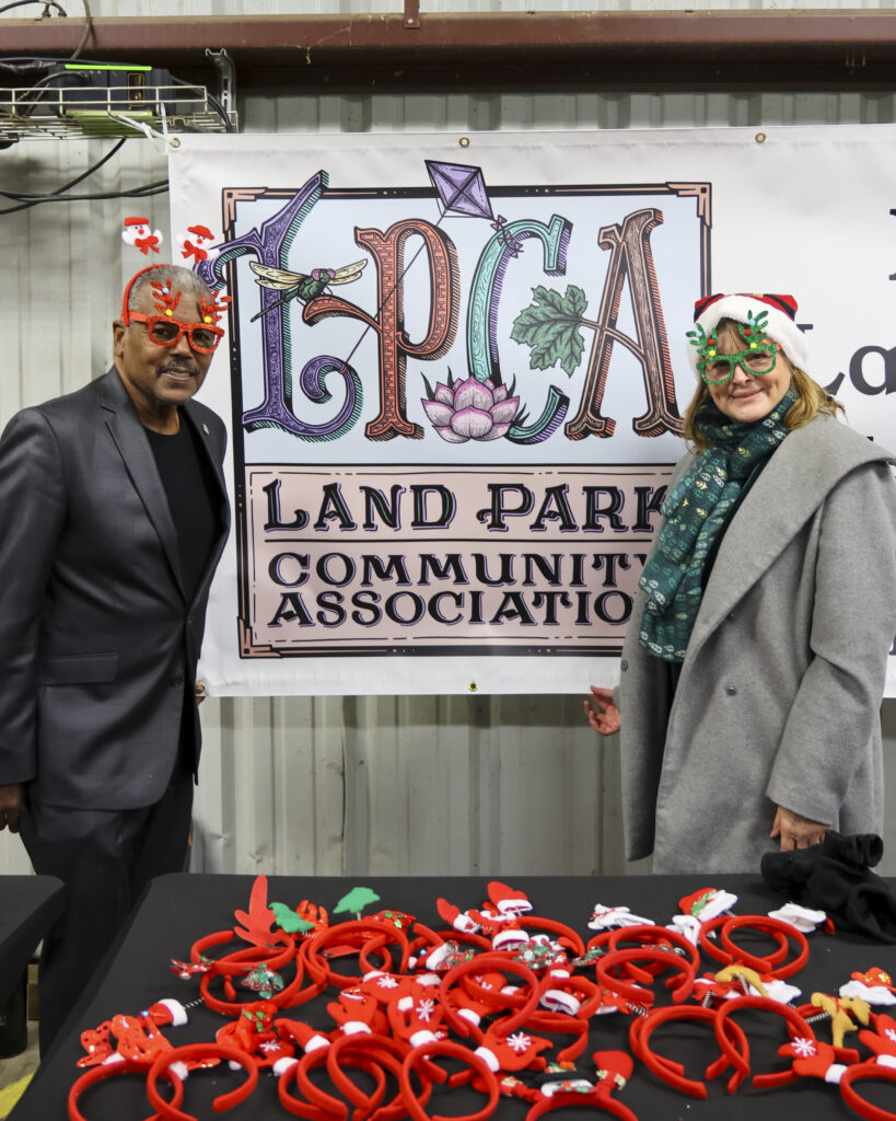 City councilman Rick Jennings and Land Park Community Association boardmember Kristina Rogers pose in front of a LPCA sign.