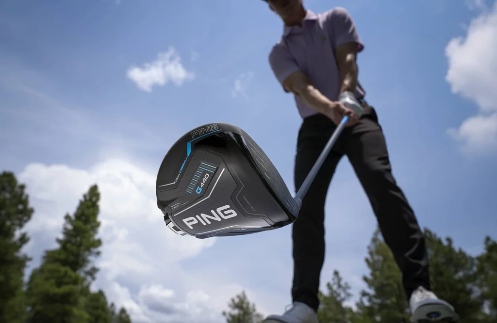 A below angle photo of golfer holding a PING G440K driver.