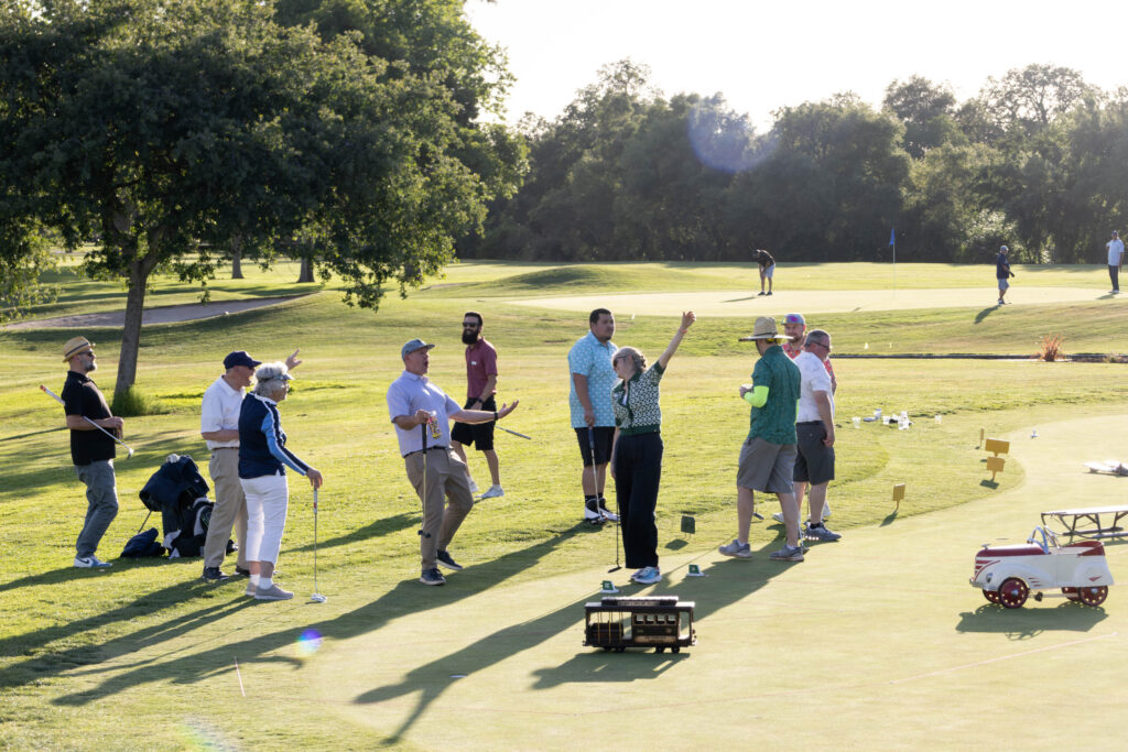 A wide shot of the Morton Golf Foundation Putting Party from 2025. A team of golfers are cheering after a good putt.
