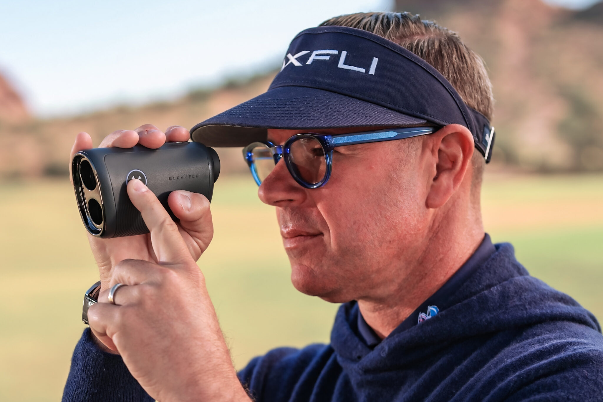 Man Holding a Blue Tee Captain Pro Range finder