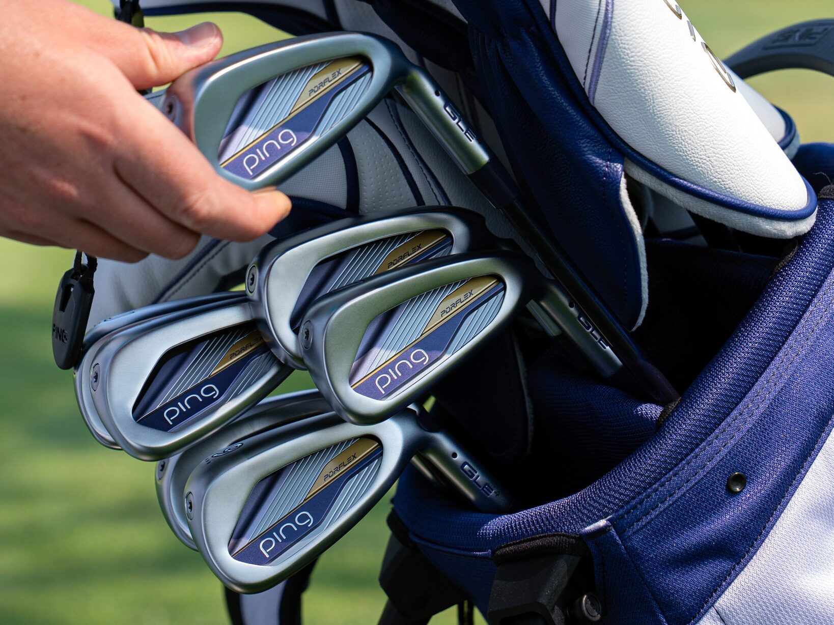 PING G Le4 Irons in a bag with soemone reaching in to grab one.