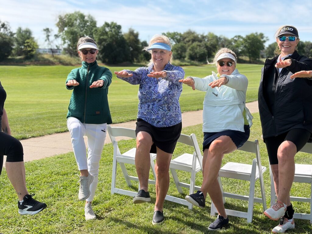 3 women doing an exercise move on a golf course