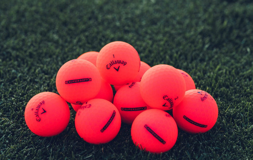 A pile of several pink Callaway golf balls.