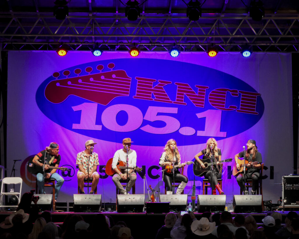 6 musical artists performing music on a stage