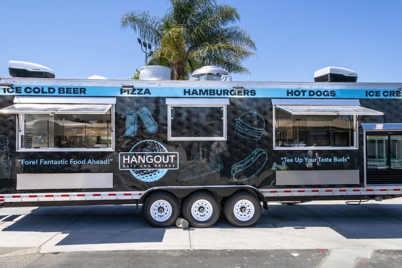 The Hangout food truck at Haggin Oaks serving beer, pizza, hamburgers, hot dogs, and ice cream with ordering windows on both sides