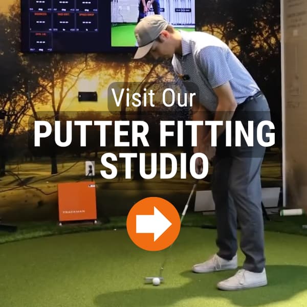 Golfer practicing putting indoors at a fitting studio using a launch monitor and screen analysis, with putters displayed nearby.